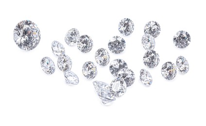 Photo of Many beautiful shiny diamonds on white background