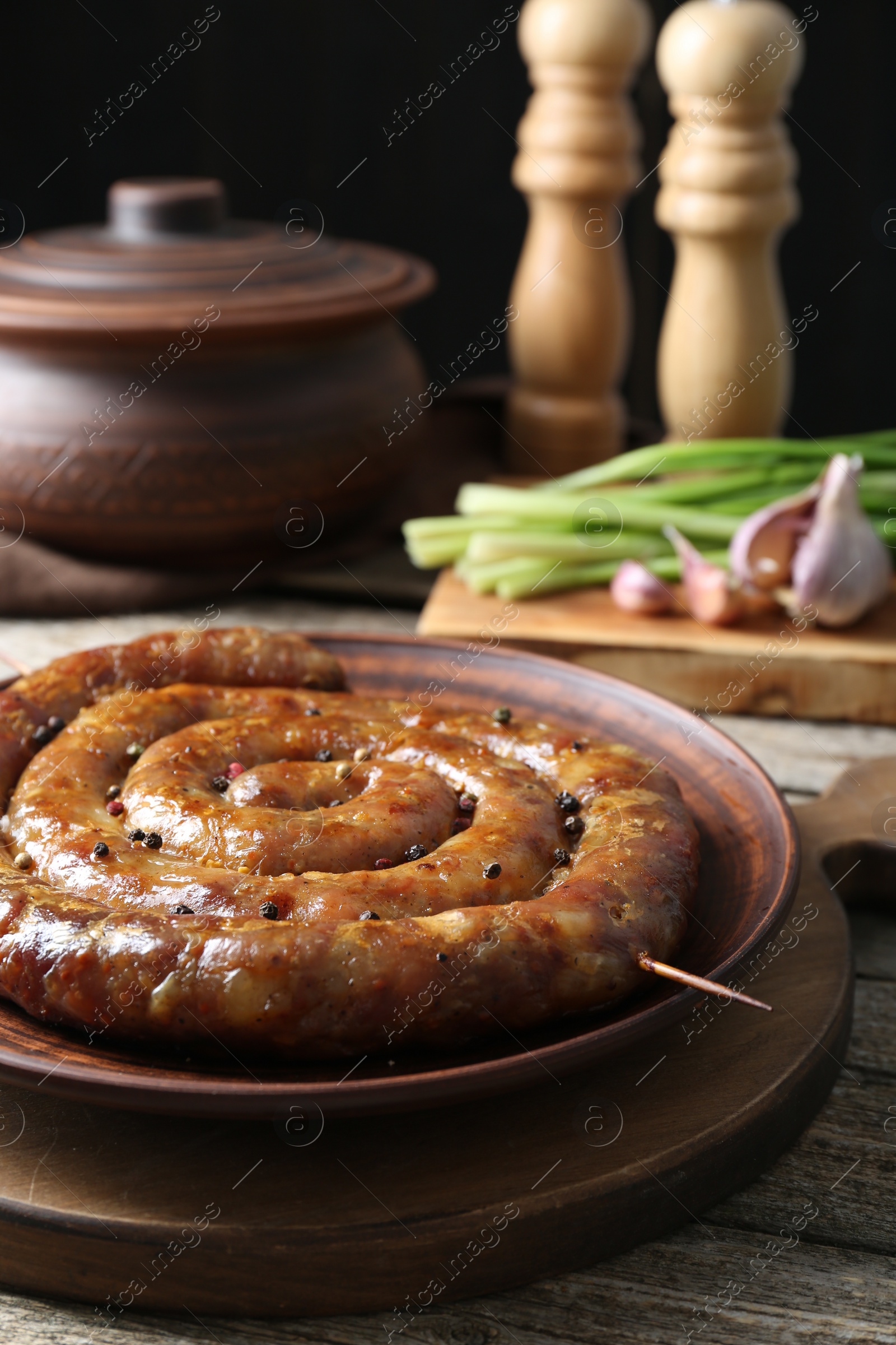 Photo of Plate with tasty homemade sausages on wooden table, closeup