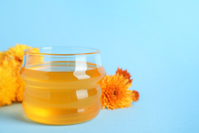 Jar of organic honey on light blue background. Space for text