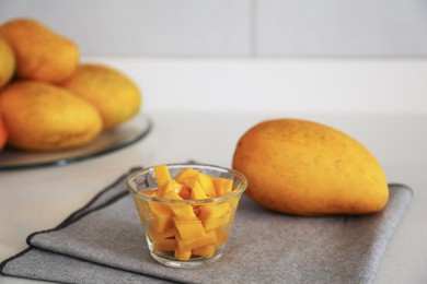 Photo of Delicious cut and whole mangoes on light table