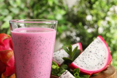 Photo of Delicious pitahaya smoothie and fresh fruits on blurred background, closeup. Space for text