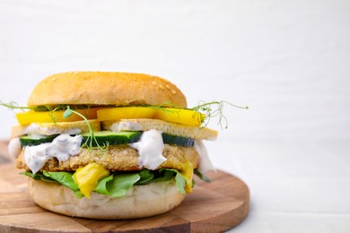 Photo of Tasty vegan burger with vegetables, sauce and patty on white background, closeup. Space for text