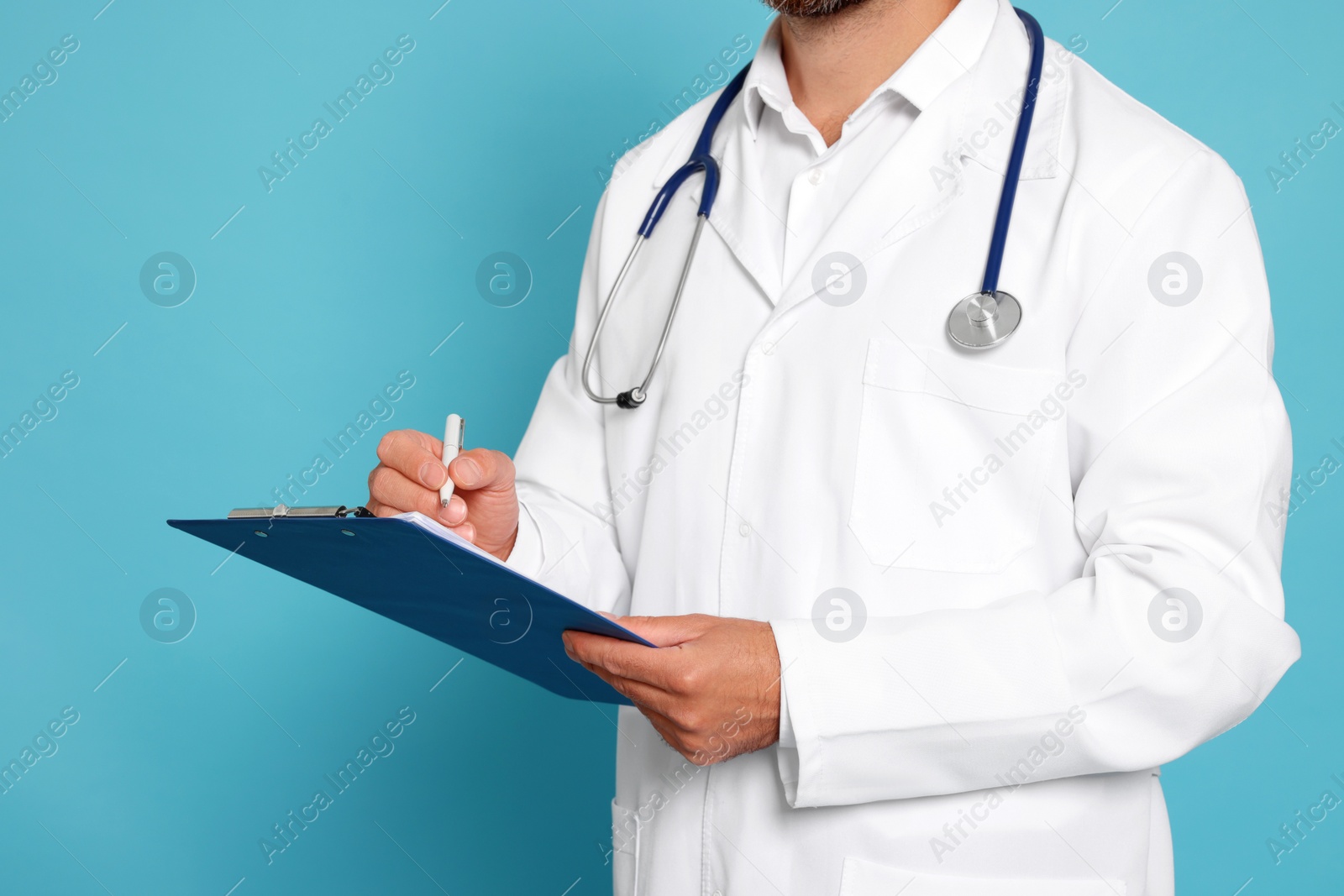 Photo of Doctor with stethoscope and clipboard on light blue background, closeup