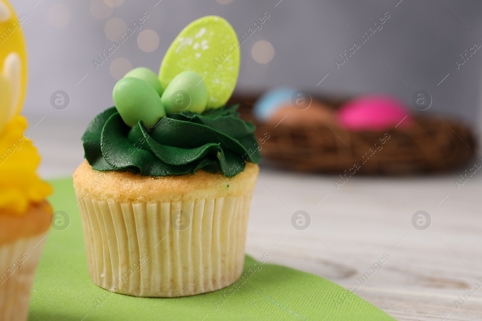 Photo of Tasty cupcake with Easter decor on wooden table, closeup. Space for text