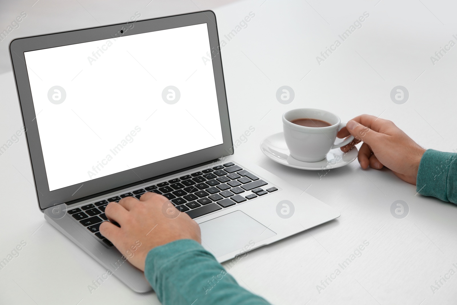 Photo of Young man working with modern laptop at table, closeup. Mockup for design