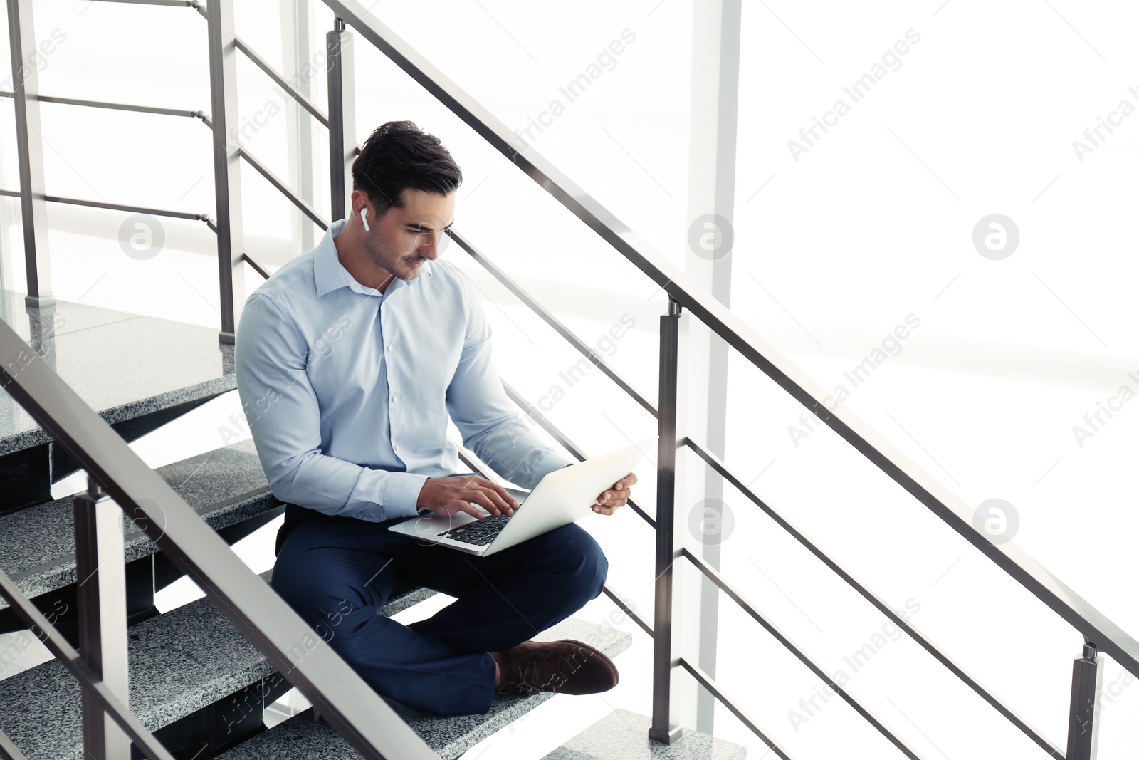 Photo of Portrait of young man with laptop indoors