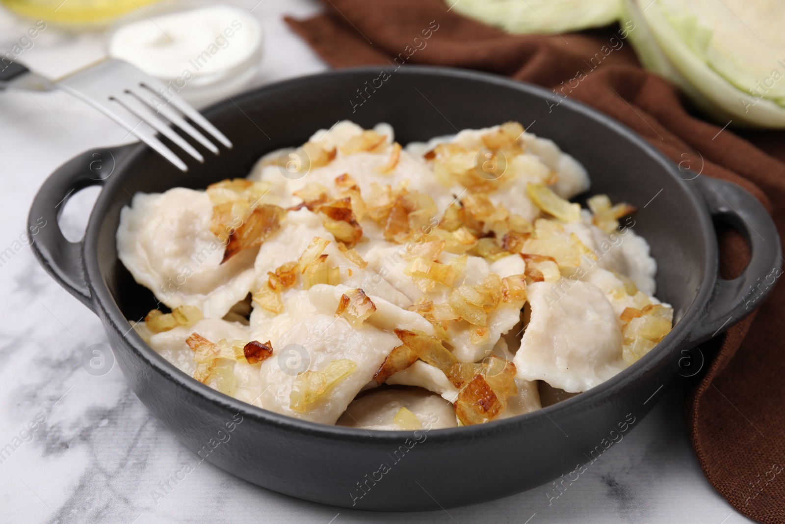 Photo of Cooked dumplings (varenyky) with tasty filling and fried onions on white marble table, closeup
