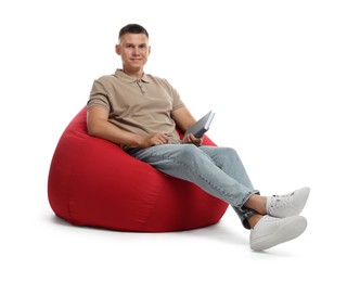 Photo of Handsome man with book sitting on red bean bag chair against white background