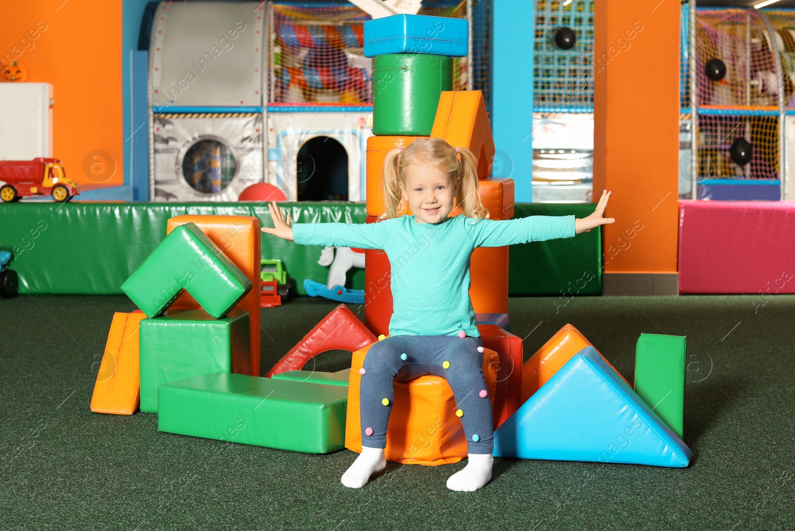 Photo of Cute child playing with colorful building blocks indoors