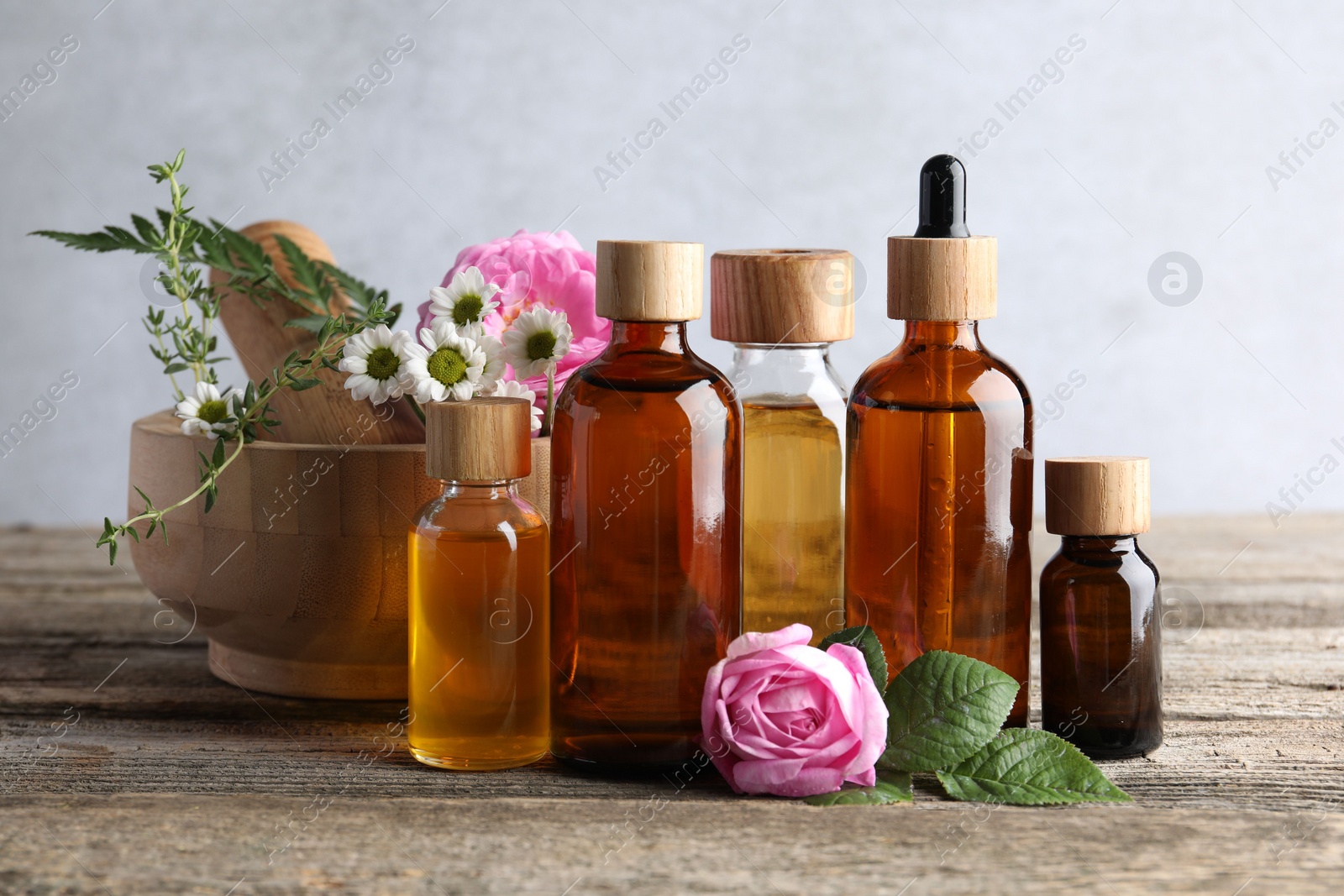 Photo of Aromatherapy. Different essential oils and flowers on wooden table