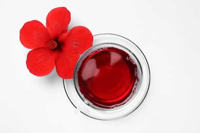 Delicious hibiscus tea and beautiful flower on white background, flat lay