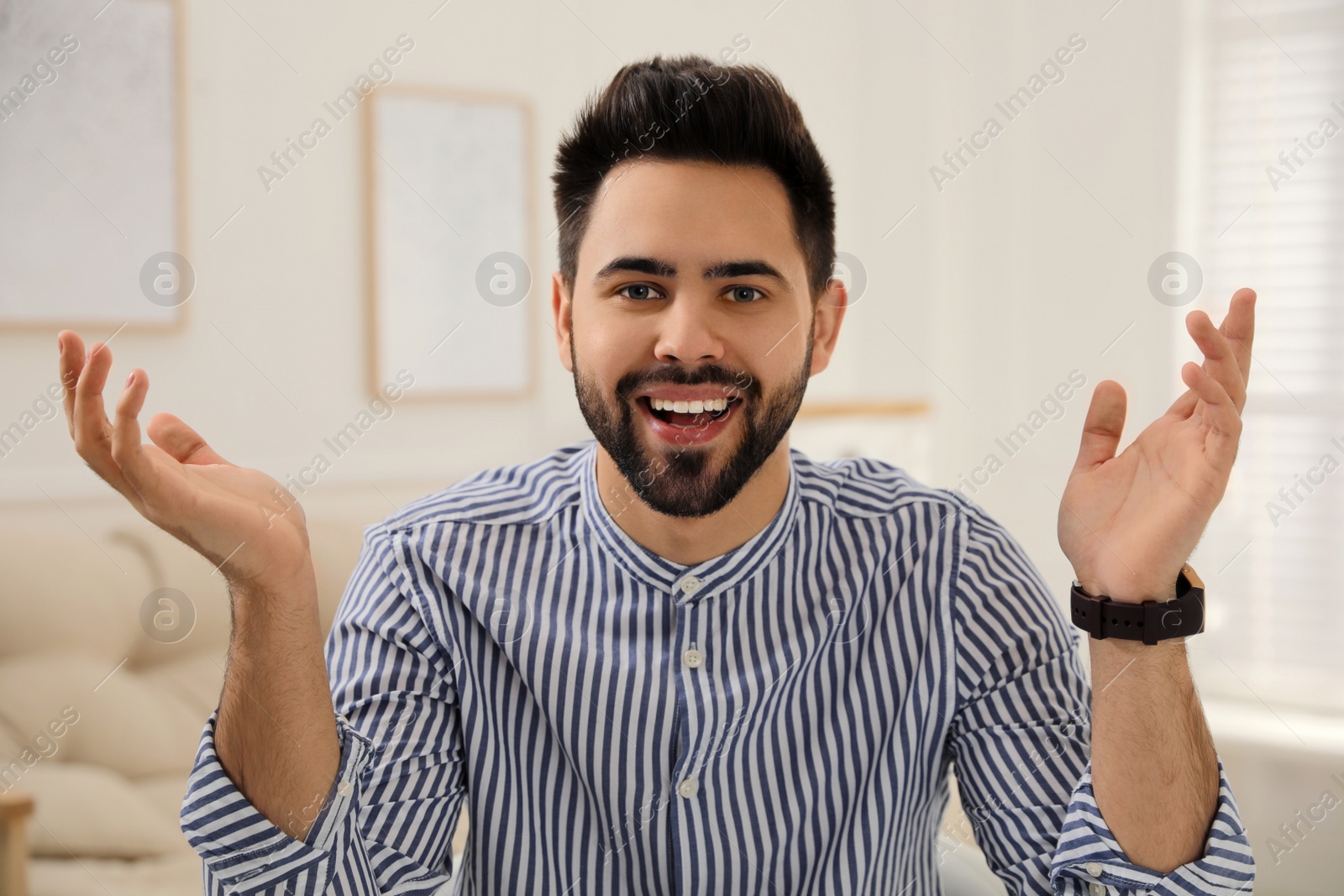 Photo of Young man conducting webinar in room at home