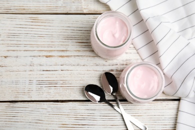 Flat lay composition with creamy yogurt and space for text on white wooden background