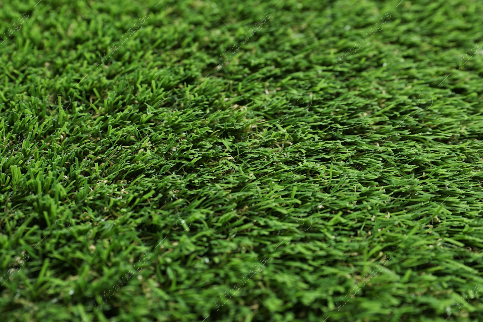 Photo of Green artificial grass texture as background, closeup