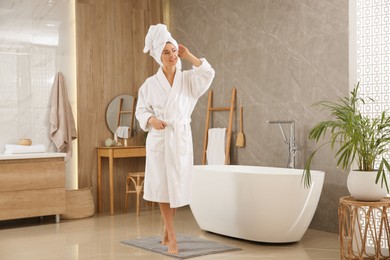 Photo of Beautiful woman wearing white robe in bathroom