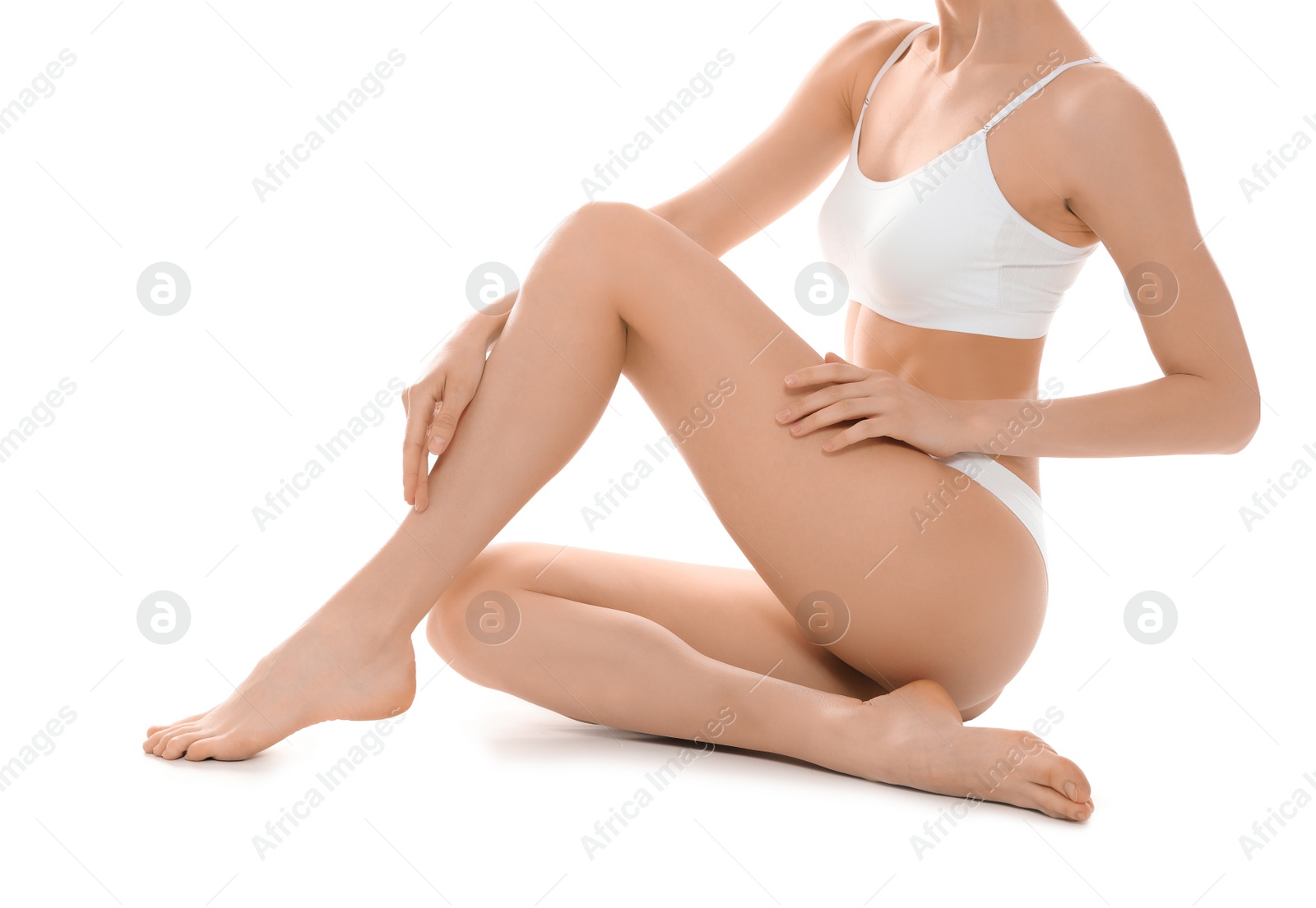 Photo of Slim young woman with smooth skin sitting on white background. Beauty and body care concept