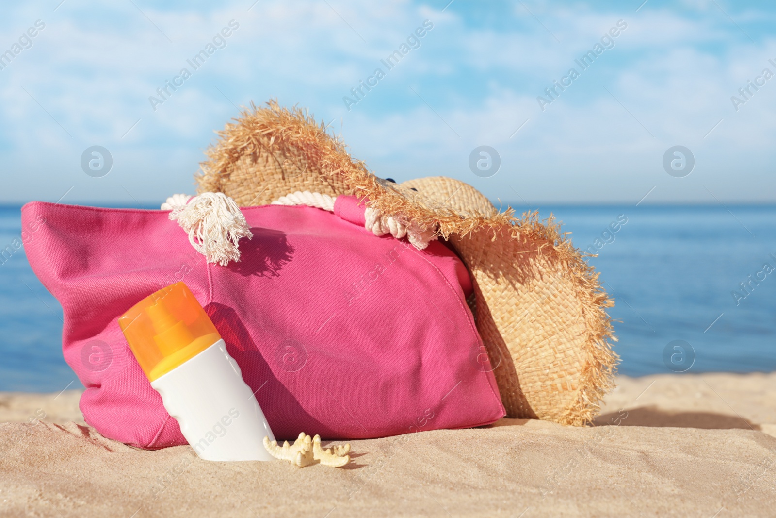 Photo of Stylish beach accessories on sand near sea