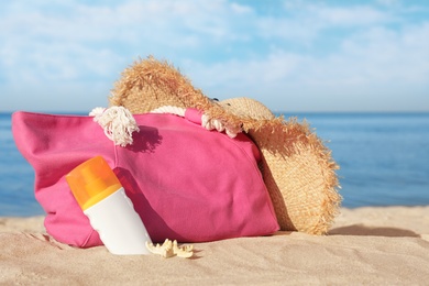 Stylish beach accessories on sand near sea