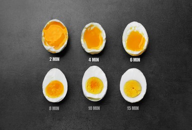 Image of Different readiness stages of boiled chicken eggs on dark grey table, flat lay