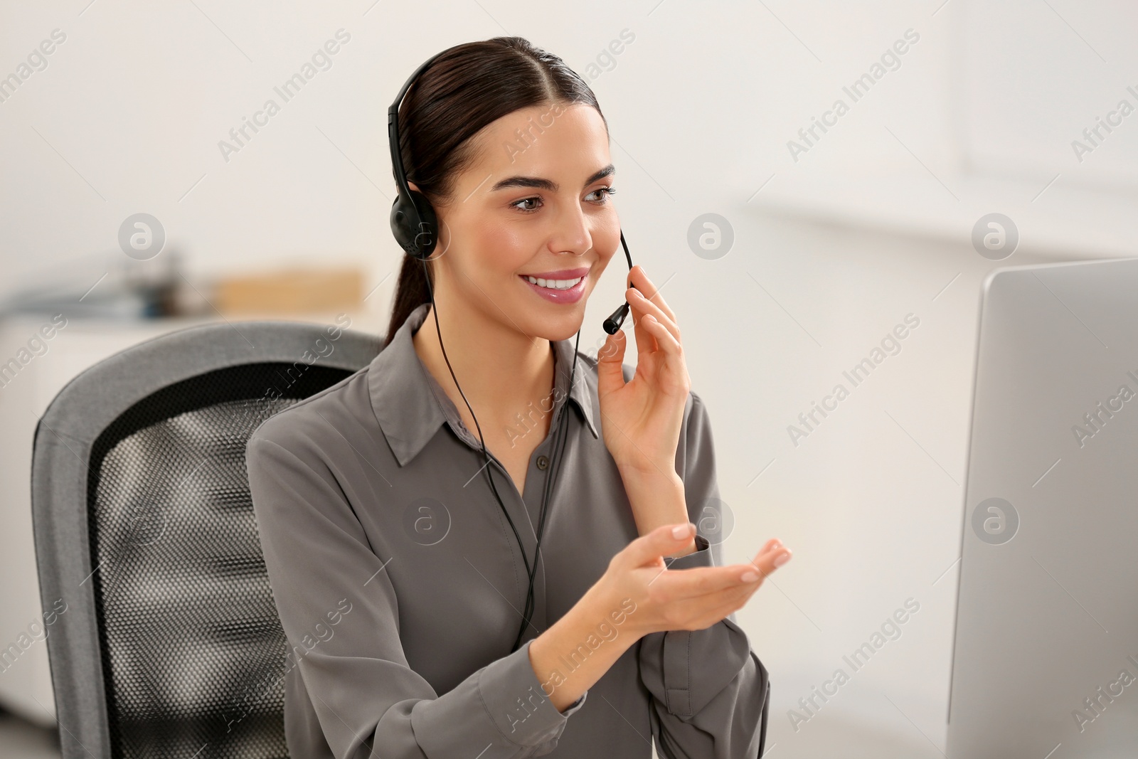 Photo of Hotline operator with headset working in office