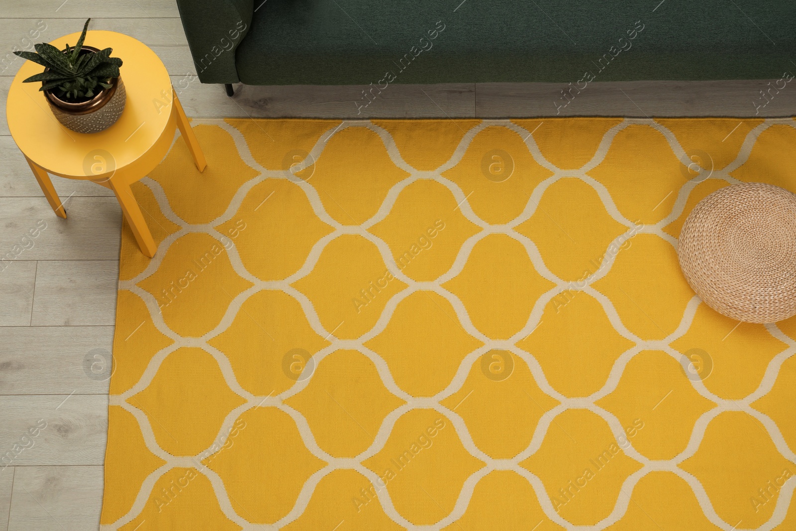 Photo of Yellow carpet with geometric pattern on wooden floor in living room, above view