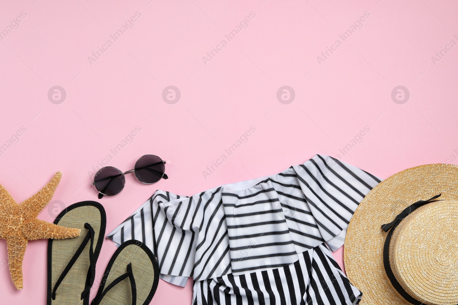 Photo of Flat lay composition with stylish beach accessories on pink background, space for text