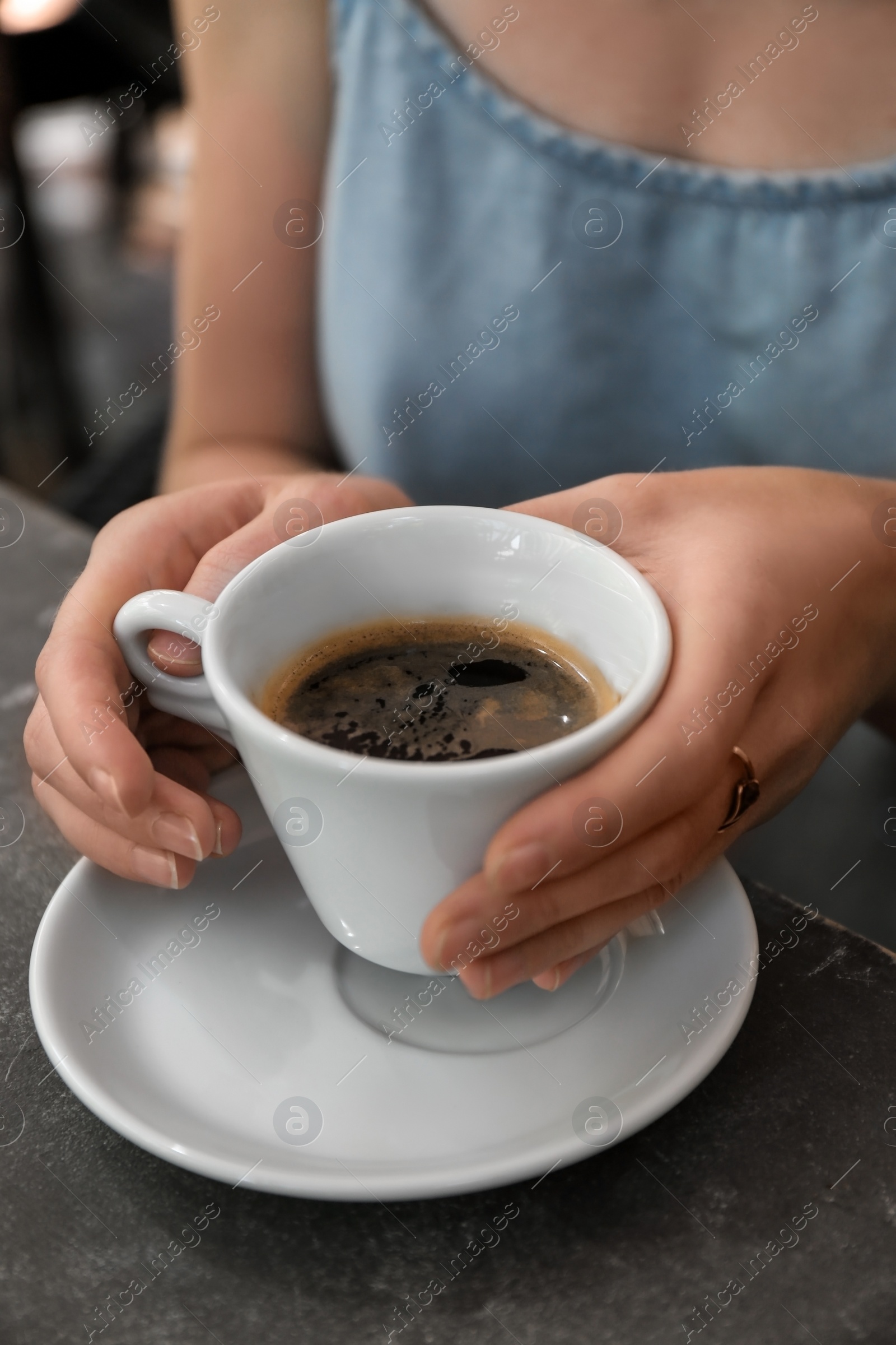 Photo of Woman with cup of fresh aromatic coffee at table, closeup