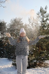 Woman playing with snow in winter forest