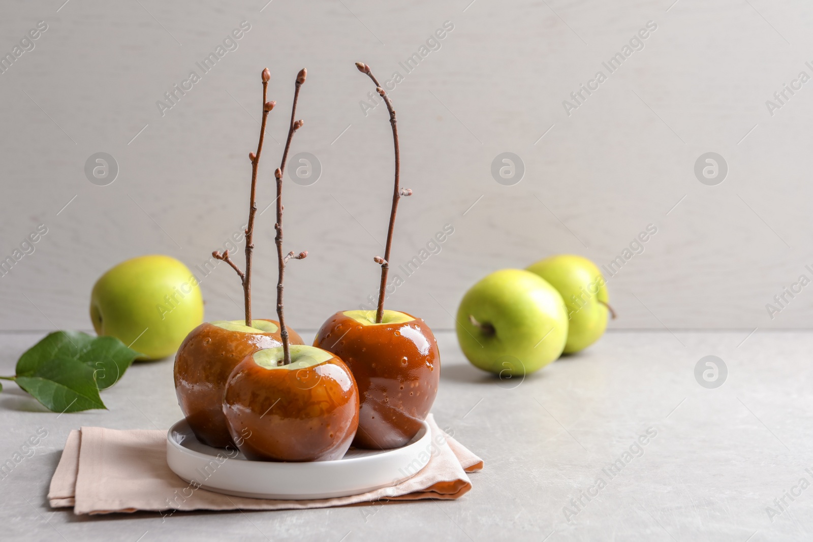 Photo of Plate with delicious green caramel apples on table