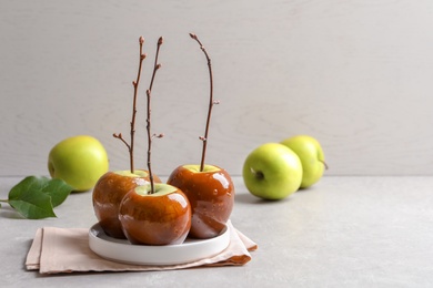 Photo of Plate with delicious green caramel apples on table