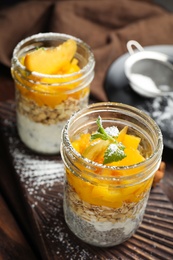 Photo of Tasty peach dessert with yogurt and granola on wooden table