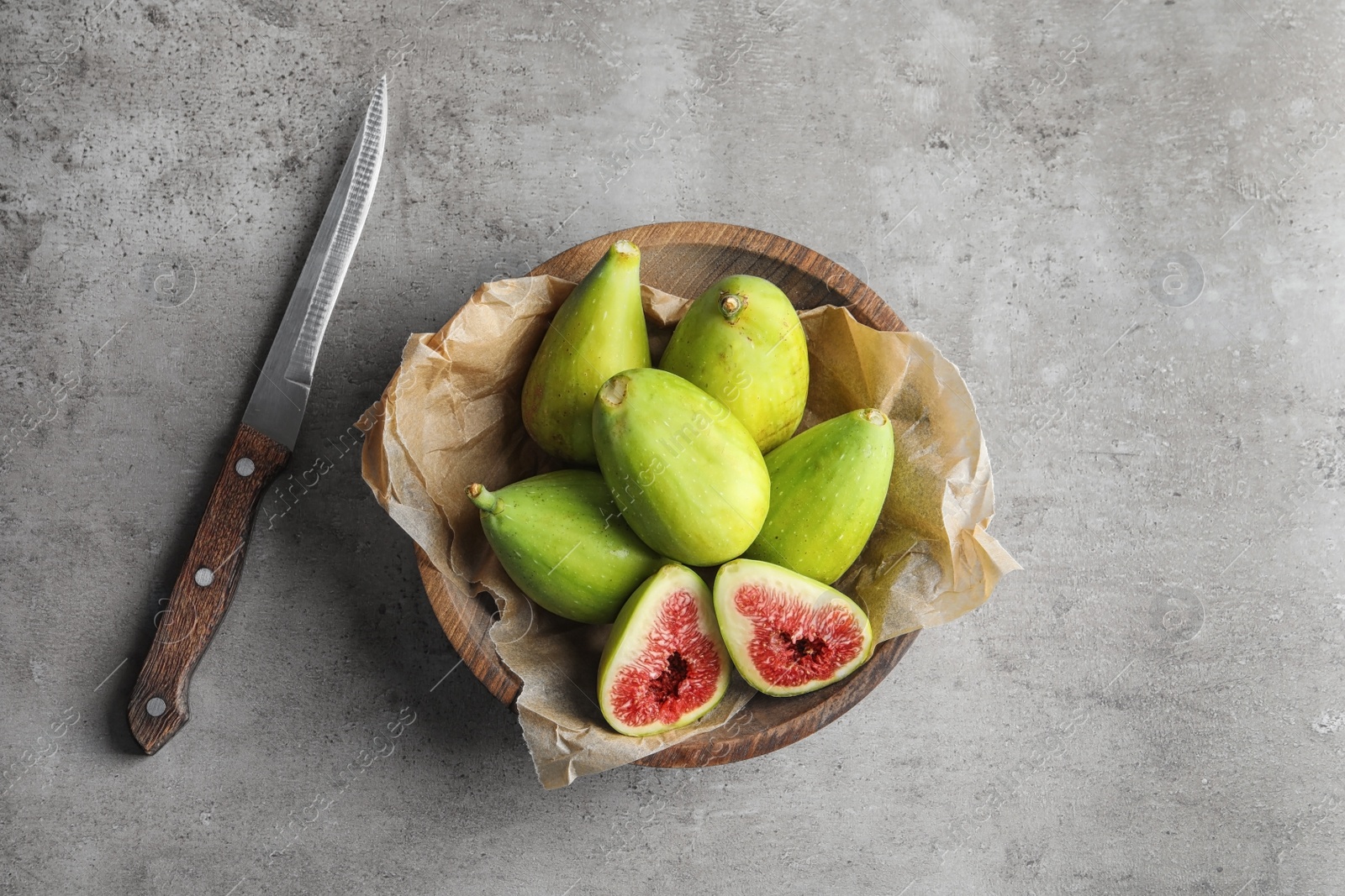 Photo of Bowl with fresh ripe figs on gray background, top view