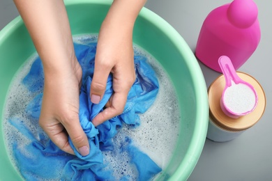 Photo of Woman washing color clothes in basin, closeup