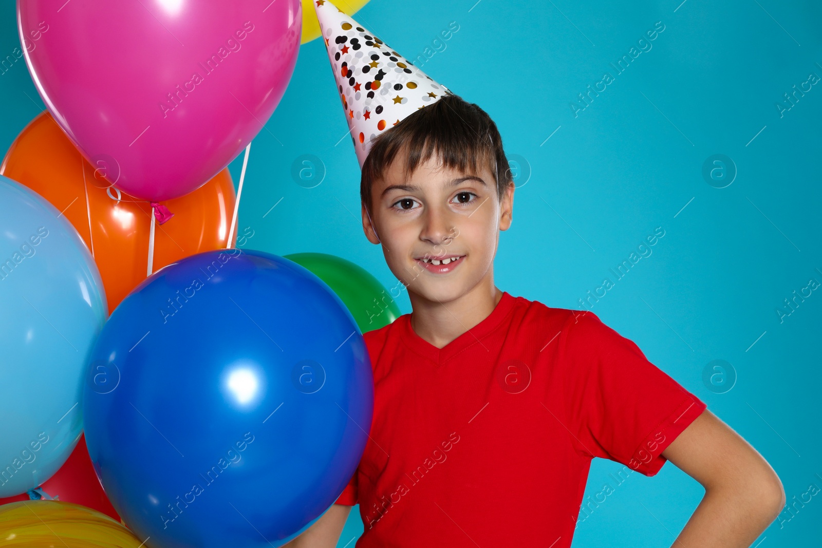 Photo of Happy boy with balloons on blue background. Birthday celebration