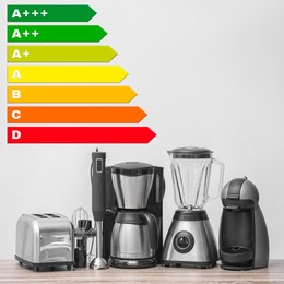 Image of Energy efficiency rating label and kitchen appliances on wooden table