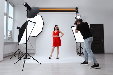 Photo of Beautiful young model posing for professional photographer in studio