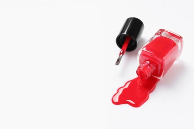 Photo of Spilled color nail polish with bottle and brush on white background