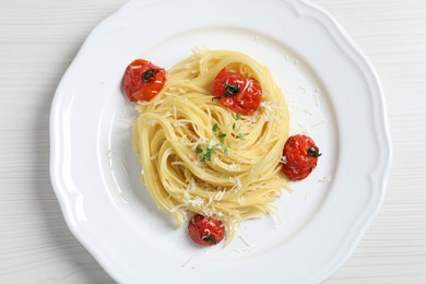 Photo of Tasty capellini with tomatoes and cheese on white wooden table, top view. Exquisite presentation of pasta dish