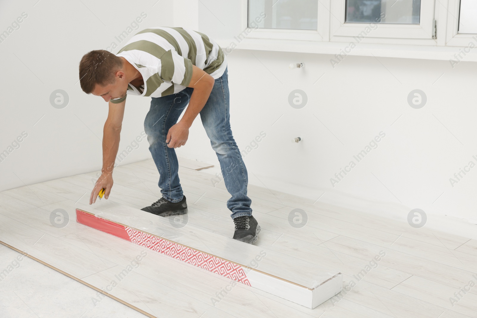 Photo of Professional worker installing new laminate flooring indoors