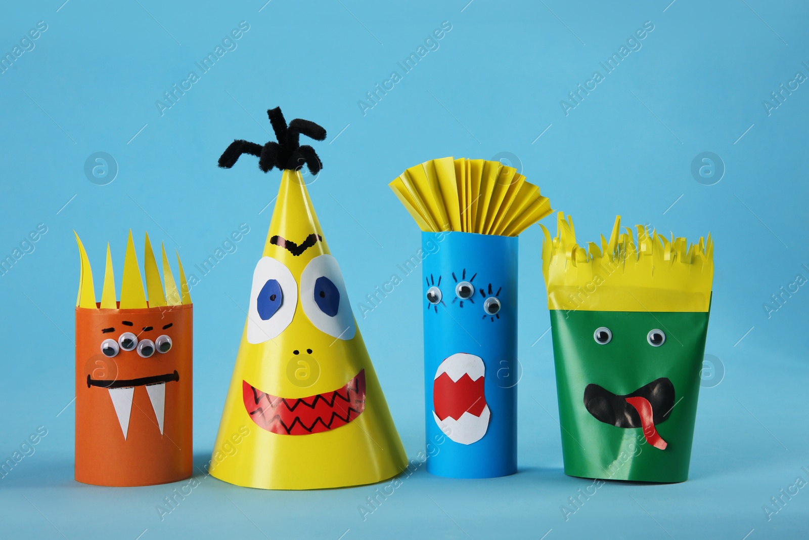 Photo of Funny monsters on light blue background. Halloween decoration