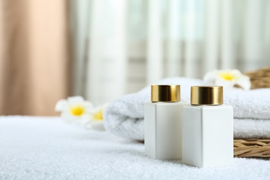 Photo of Composition with cosmetic products on white towel indoors, space for text. Spa therapy