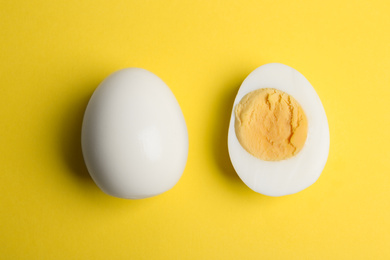 Photo of Fresh hard boiled chicken eggs on yellow background, flat lay