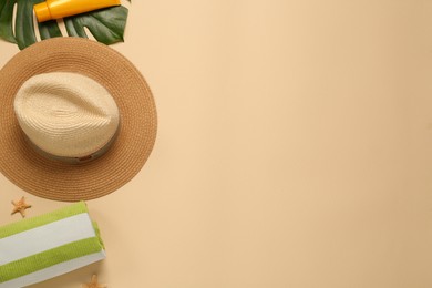 Flat lay composition with straw hat on beige background. Space for text