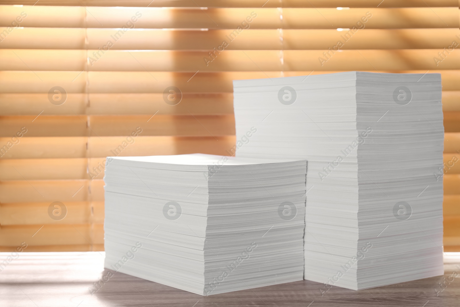 Photo of Stacks of paper sheets on wooden table