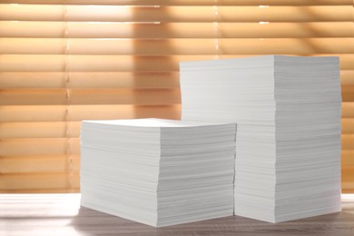 Photo of Stacks of paper sheets on wooden table