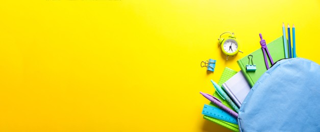 Image of Flat lay composition with backpack and school stationery on yellow background, space for text. Banner design