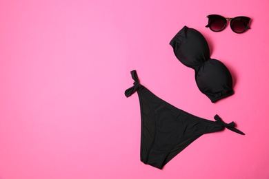 Photo of Stylish bikini and sunglasses on color background, flat lay. Space for text