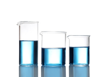 Photo of Beakers with blue liquid isolated on white. Laboratory glassware