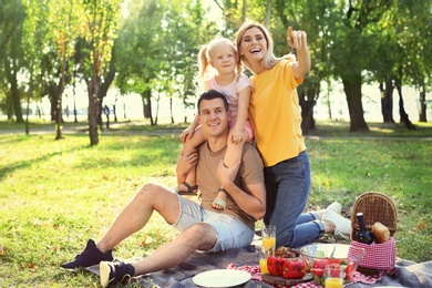 Happy family having picnic in park on sunny day