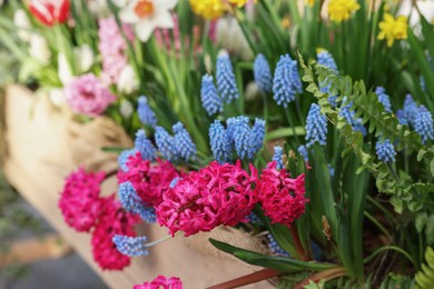 Photo of Many different flowers in wooden crate, closeup. Spring season